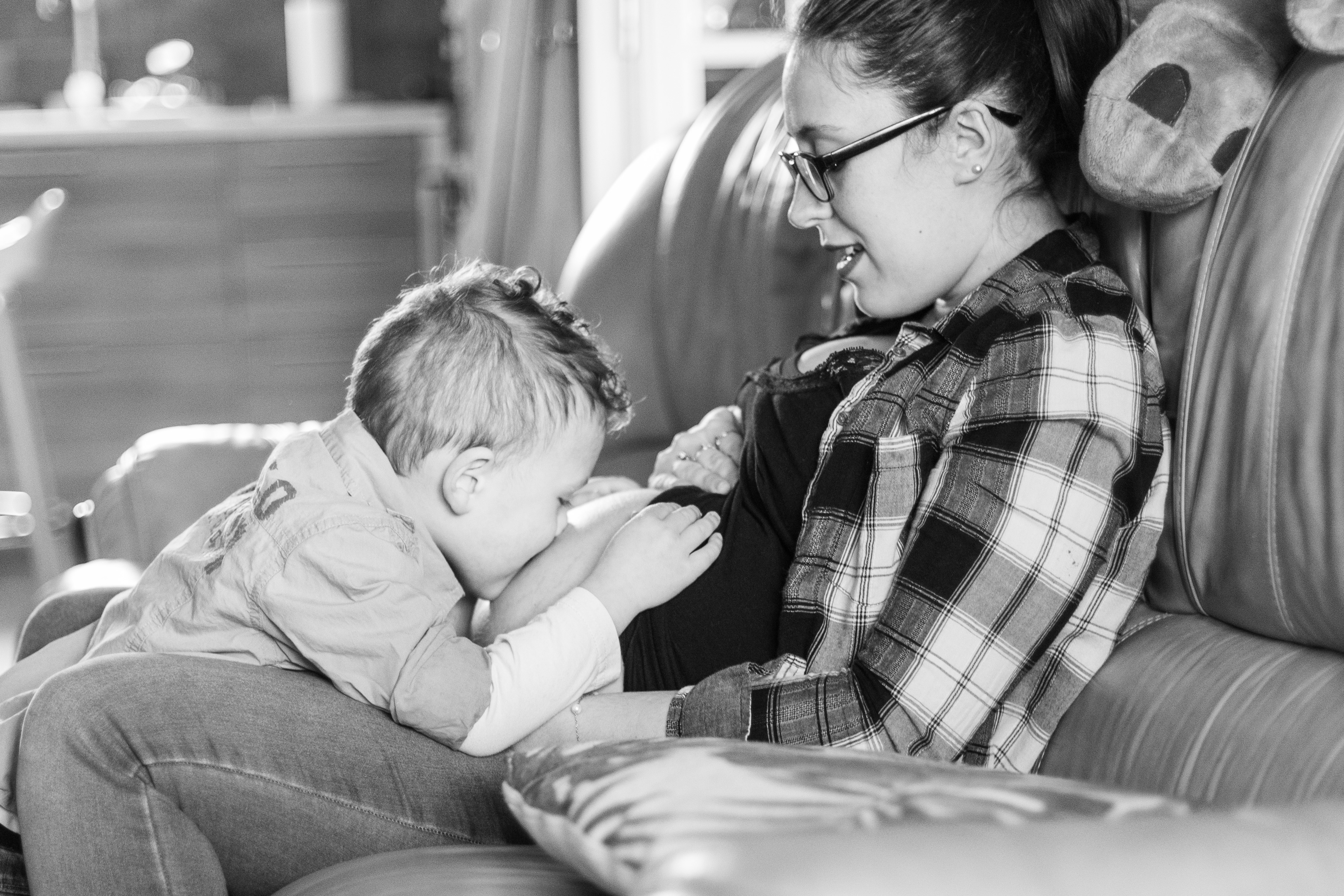 photo famille enfant fait un bisou sur le ventre de sa maman